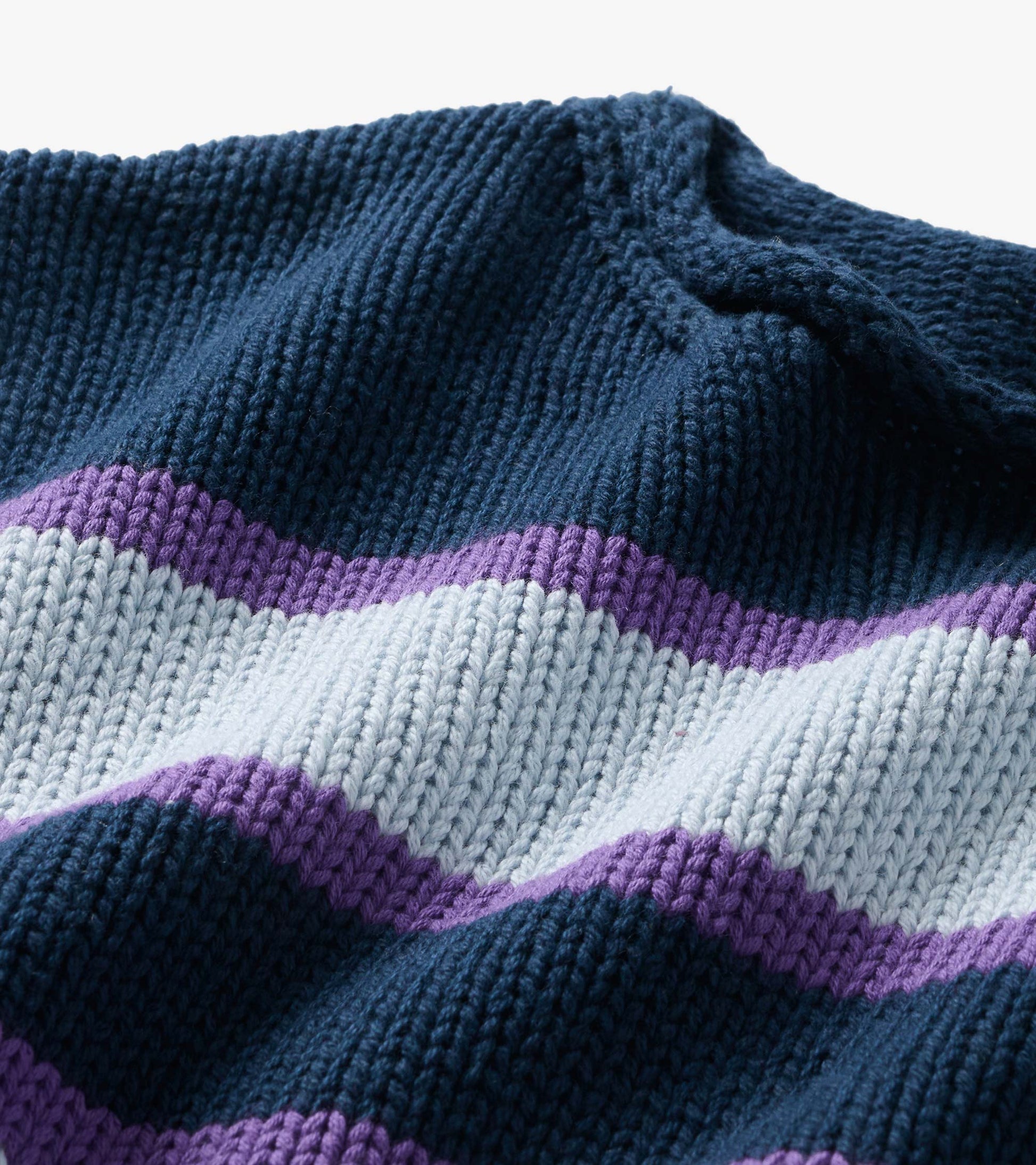 Close-up of rolled collar knit with navy, light blue, and purple stripes