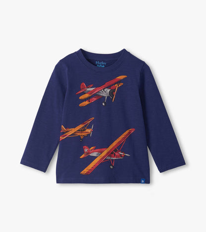 Front view of a navy long-sleeve crew neck toddler T-shirt with red, orange, and gray vintage airplane print