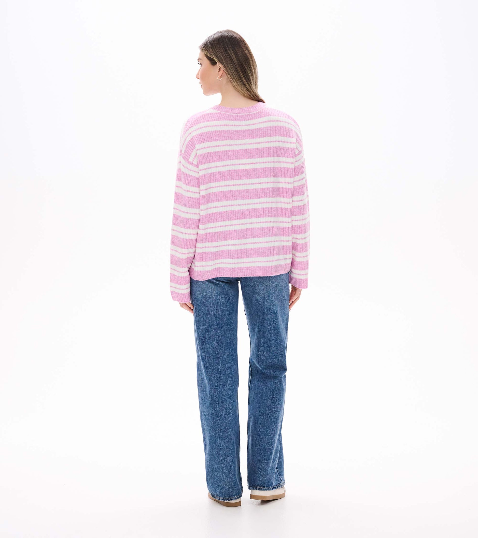 Back view of pink and cream striped sweater on model with long sleeves and relaxed shape