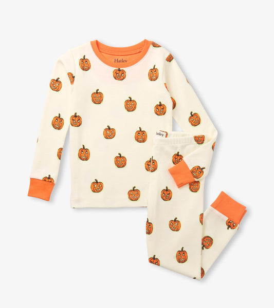 Cream kids pajama set with orange jack-o'-lantern print, long sleeves, and orange cuffs