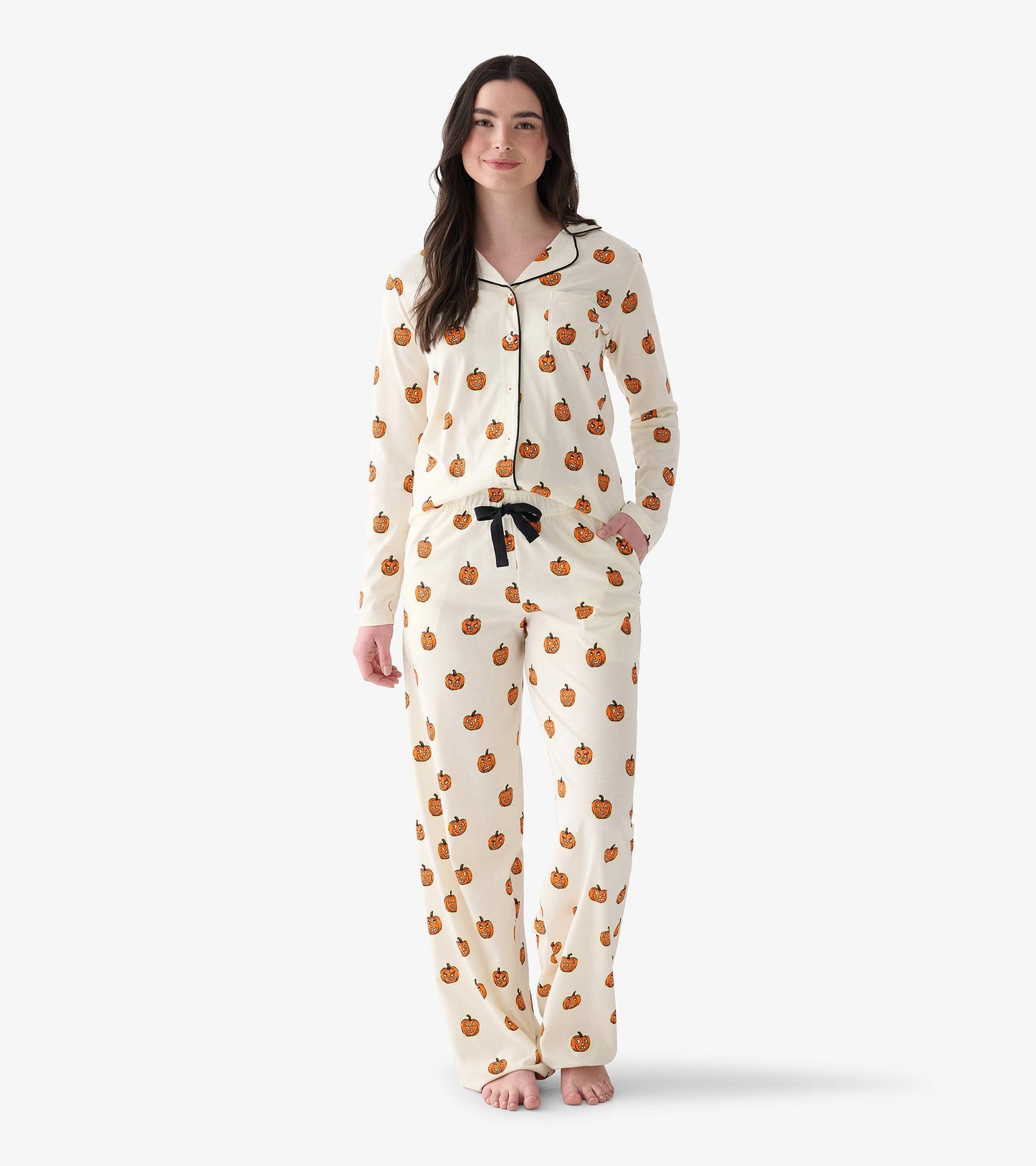 Women's cream two-piece pajamas with orange jack-o'-lantern print, black piping, and black drawstring