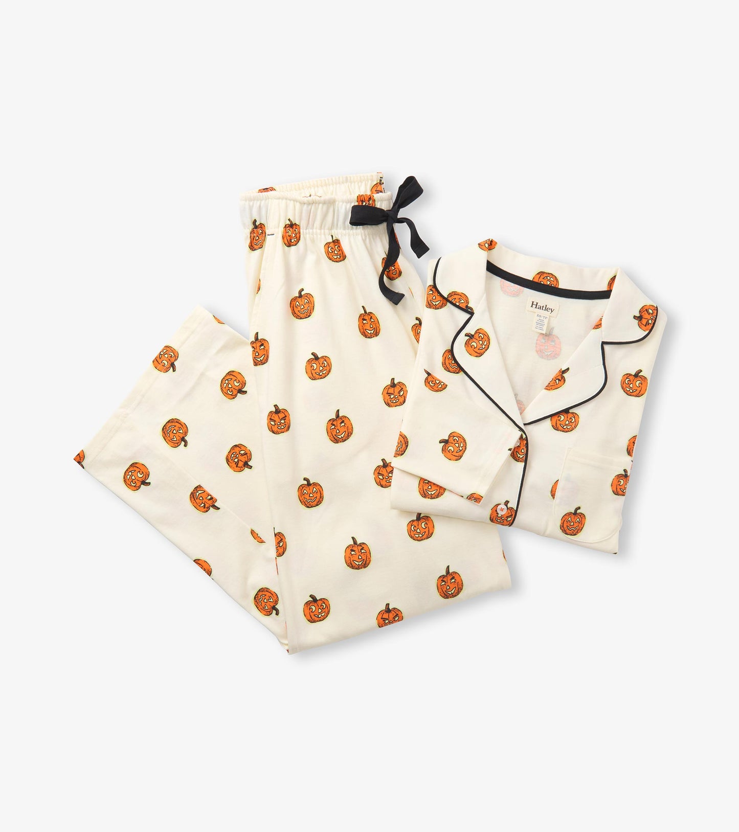 Folded cream pajama set with orange pumpkin print, black piping, and black ribbon waist tie