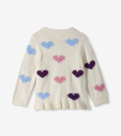 Back view of cream girls sweater with blue, pink, and purple hearts, long sleeves, and a ruffled hem