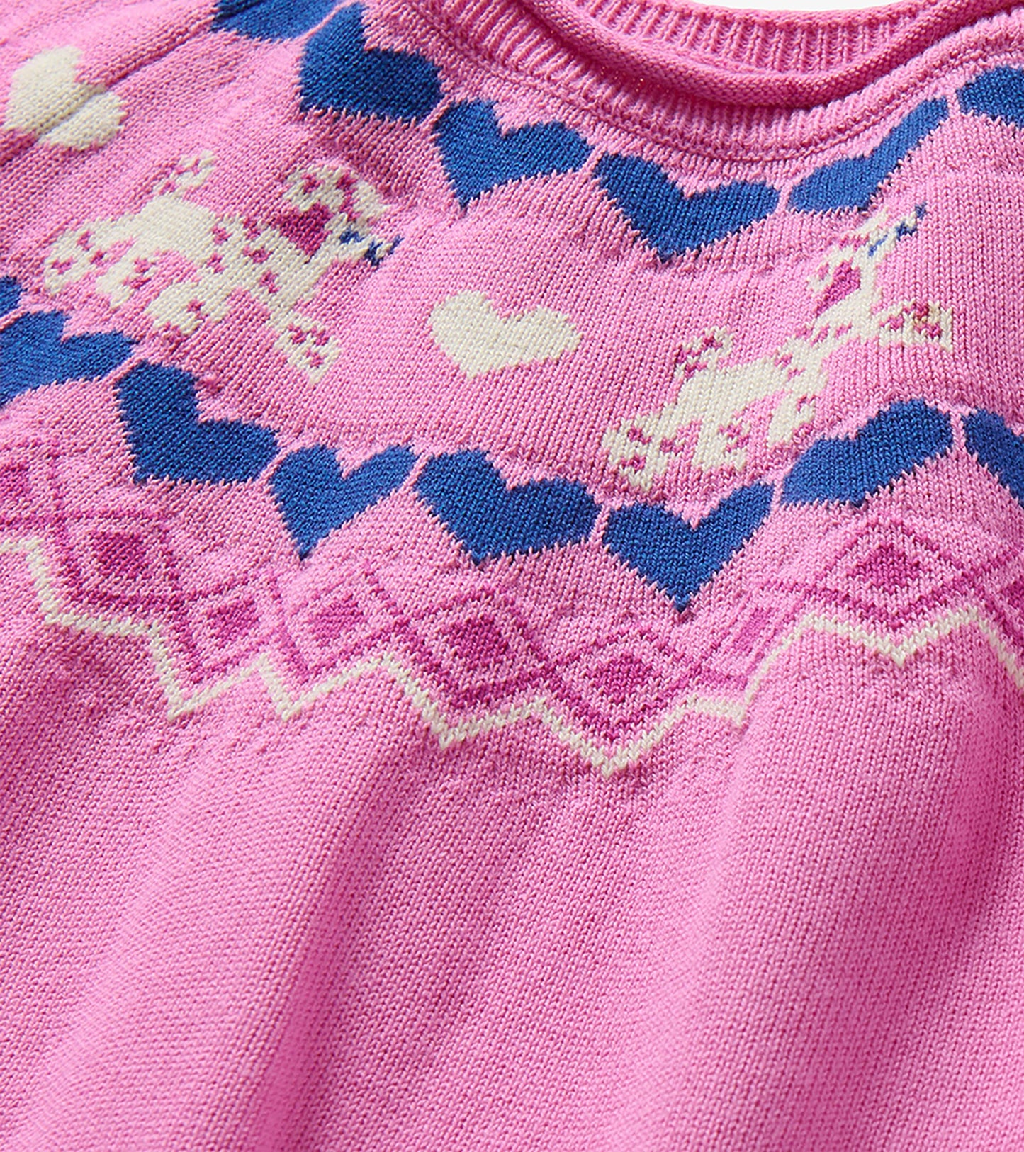 Close-up of pink knit yoke with navy hearts, cream hearts and puppy motifs