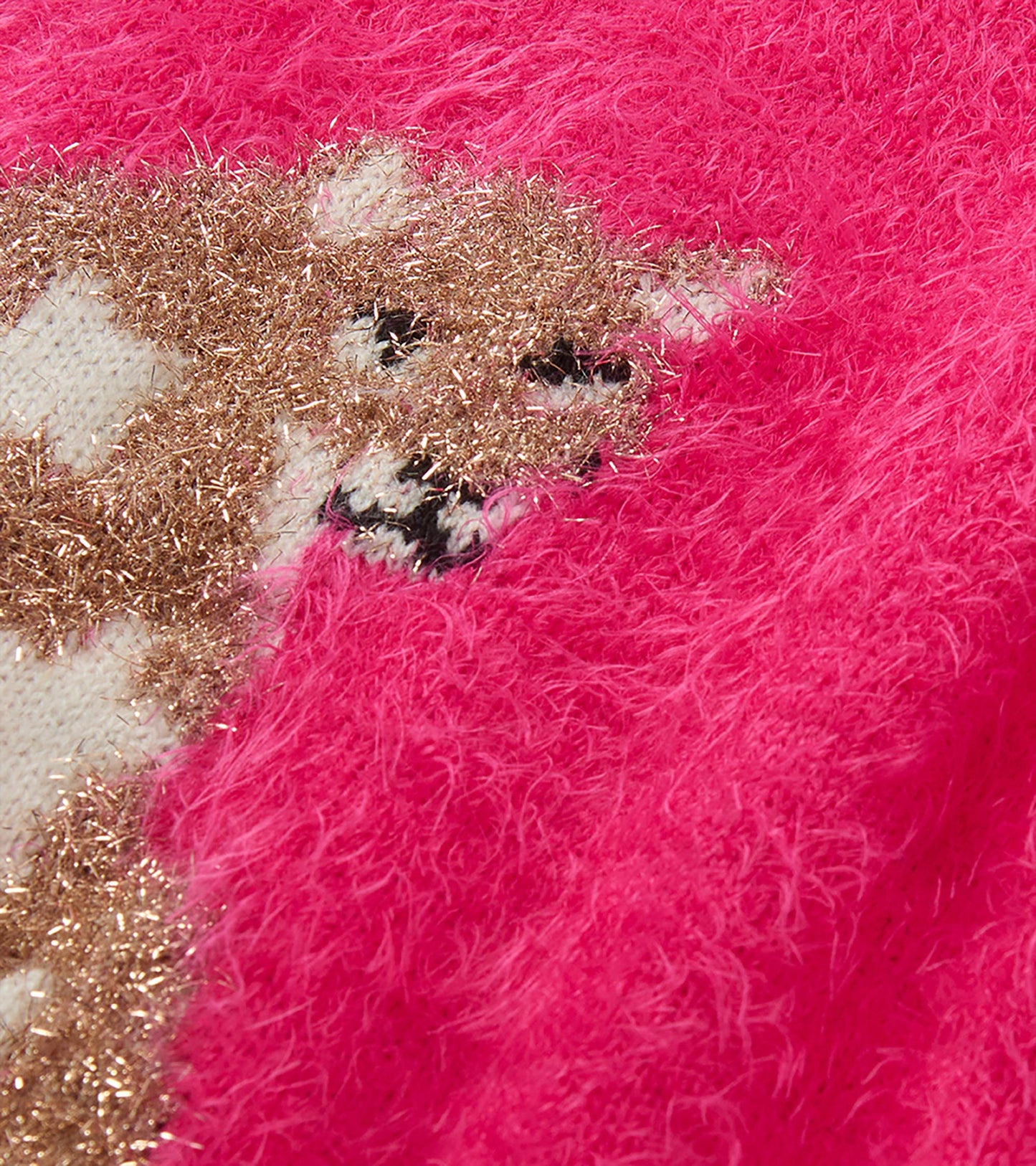 Close-up of the glittery gold cat graphic on the bright pink fuzzy sweater