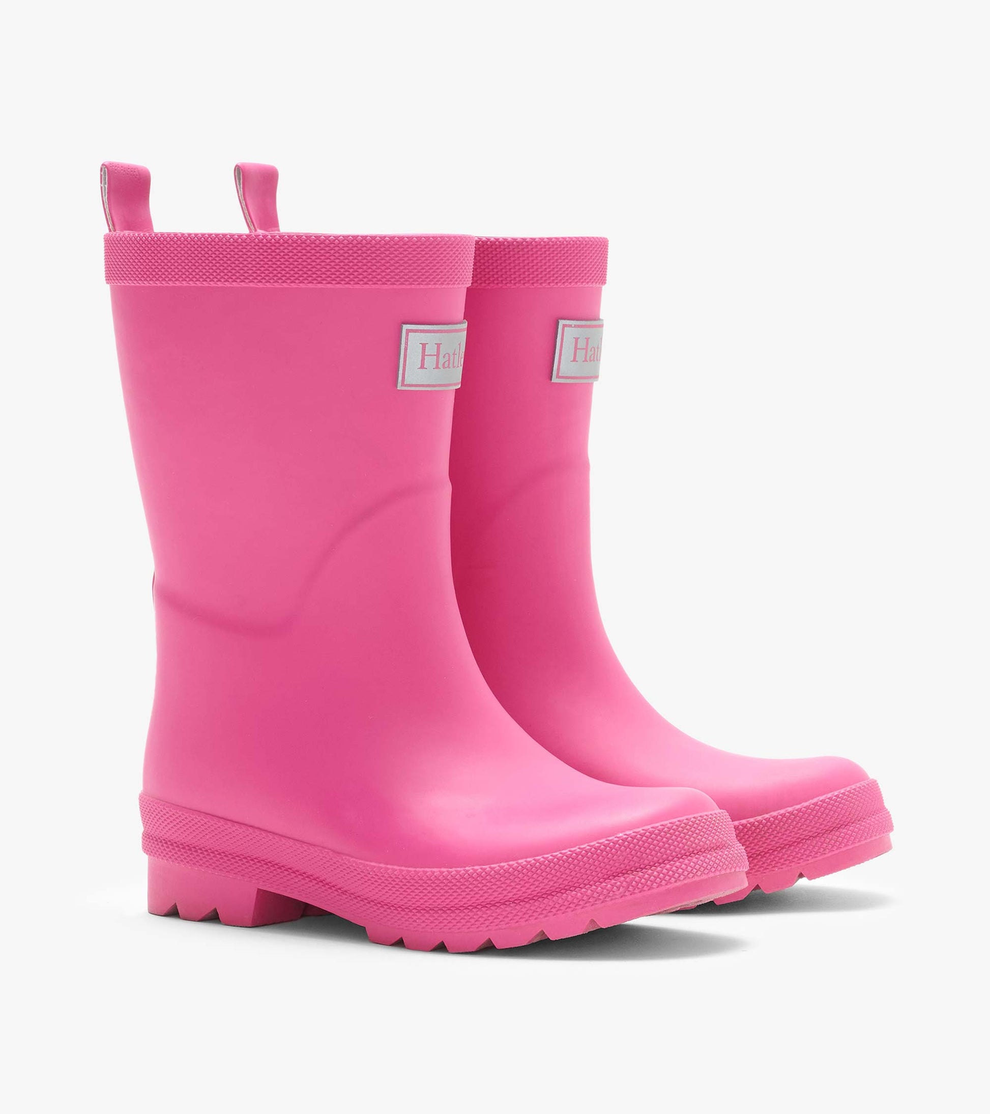 Pair of pink matte rain boots with pull tabs, textured trim, and lug soles, front side view