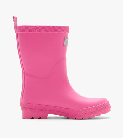 Side view of a bright pink matte rain boot with pull loop, textured trim, and lug sole