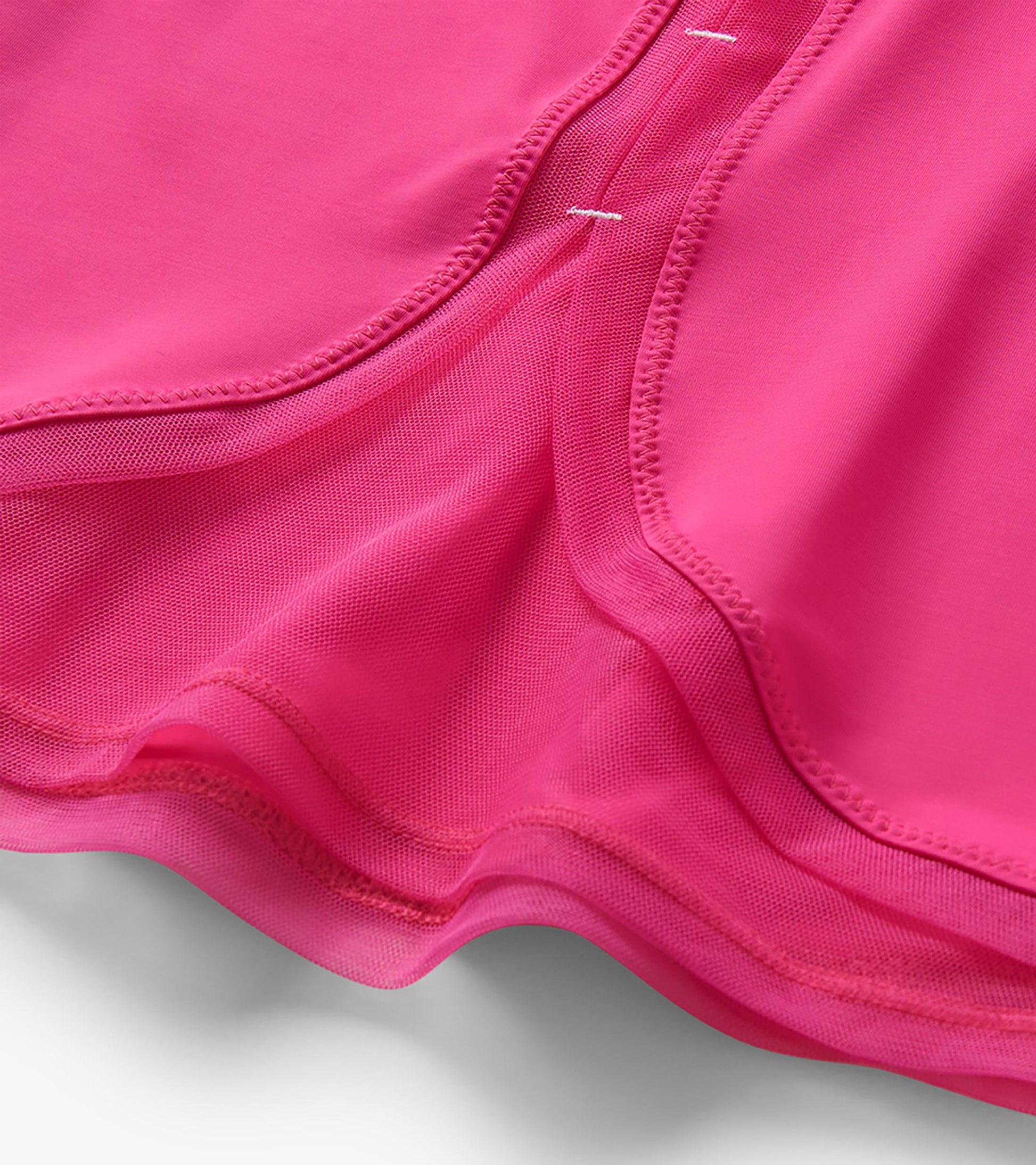Close-up of bright pink T-shirt back showing mesh panel and curved mesh hem detail