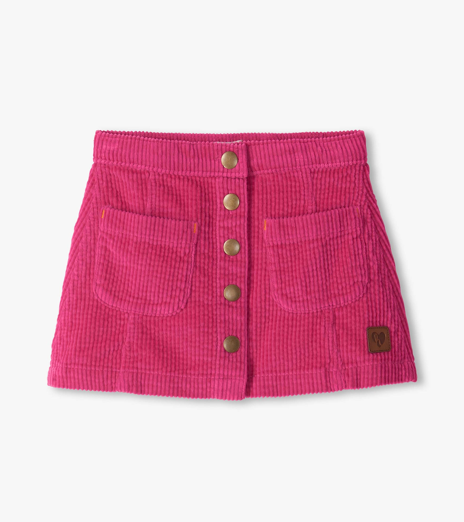 Pink A-line corduroy skirt with front snap buttons, two front pockets, and a small logo patch near the hem