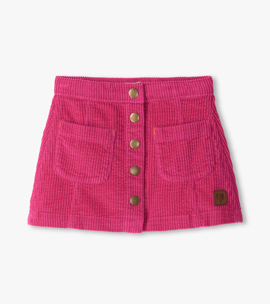 Pink A-line corduroy skirt with front snap buttons, two front pockets, and a small logo patch near the hem