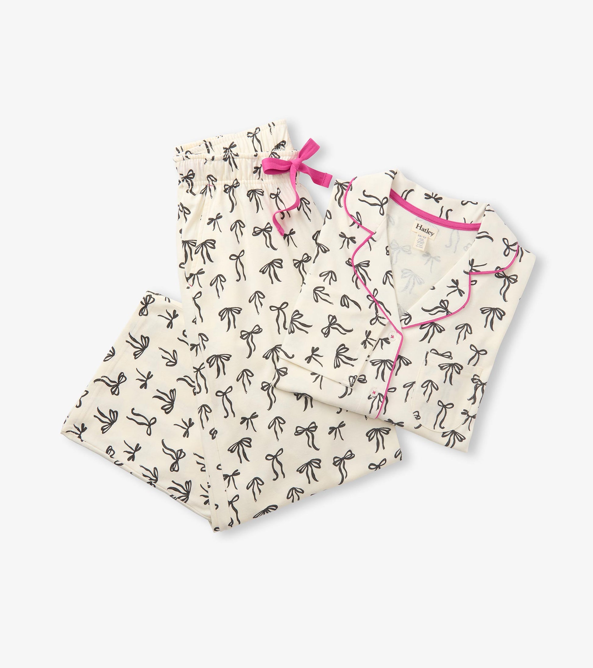 Cream pajama set with black bow print, pink piping, and matching pants with a pink drawstring bow