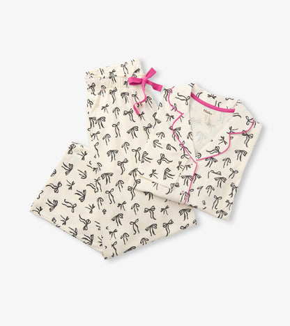 Cream pajama set with black bow print, pink piping, and matching pants with a pink drawstring bow