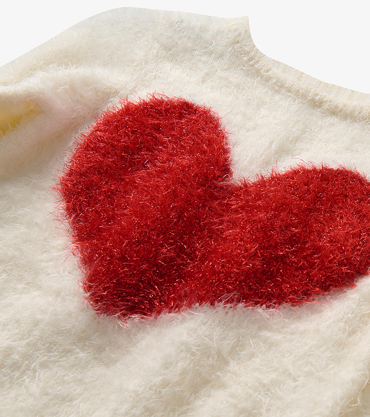 Close-up of the red heart graphic on a cream fuzzy sweater