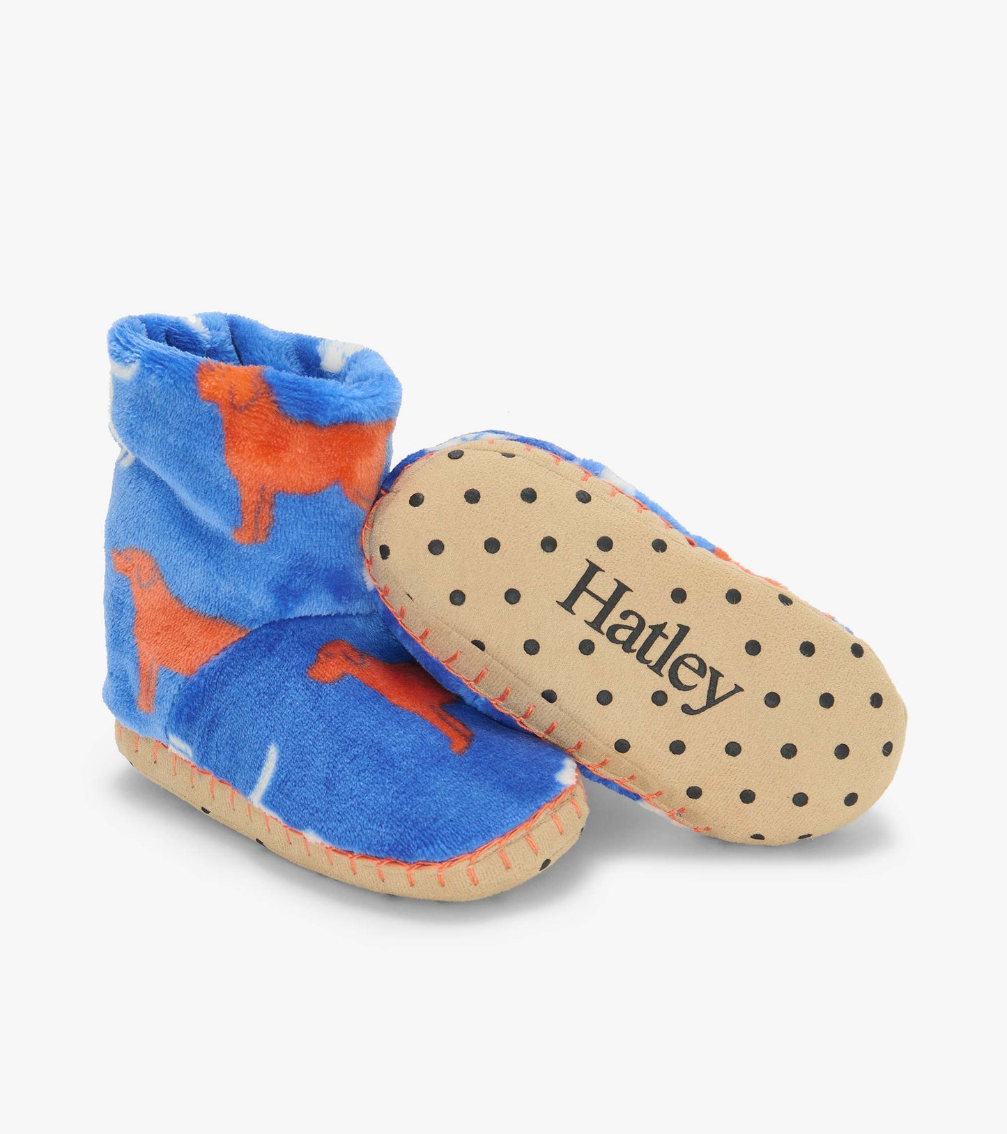 Blue dog print slipper boots with one sole facing up, showing black grip dots and Hatley logo