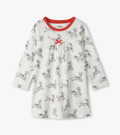 Girls white long-sleeve nightdress with leaping reindeer print, red neckline, and small red bow at the chest