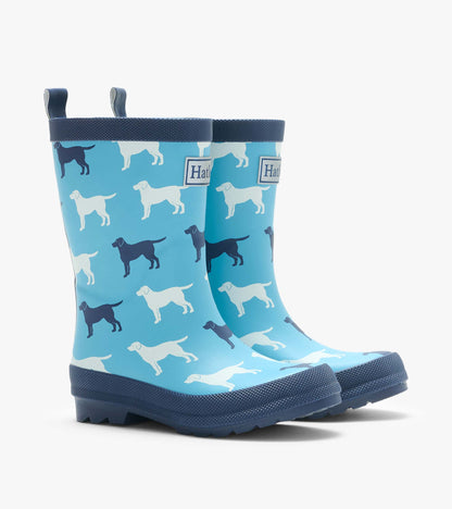 Pair of blue rain boots with white and navy dog silhouettes, shown from the front at an angle