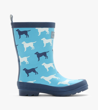 Side view of a blue rain boot with white and navy dog silhouettes and dark navy trim
