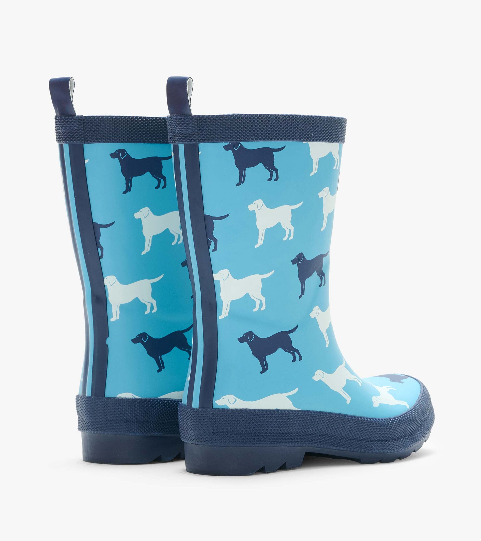 Rear angled view of blue rain boots with white and navy dog silhouettes and back pull tabs