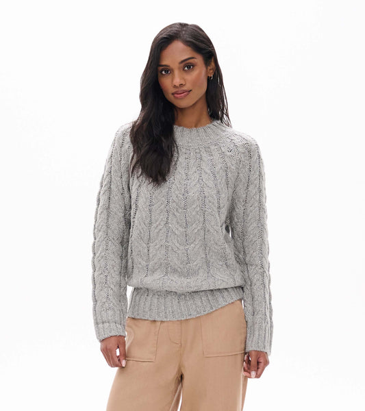 Model wearing speckle grey cable knit sweater with ribbed crew neck and hem, front view