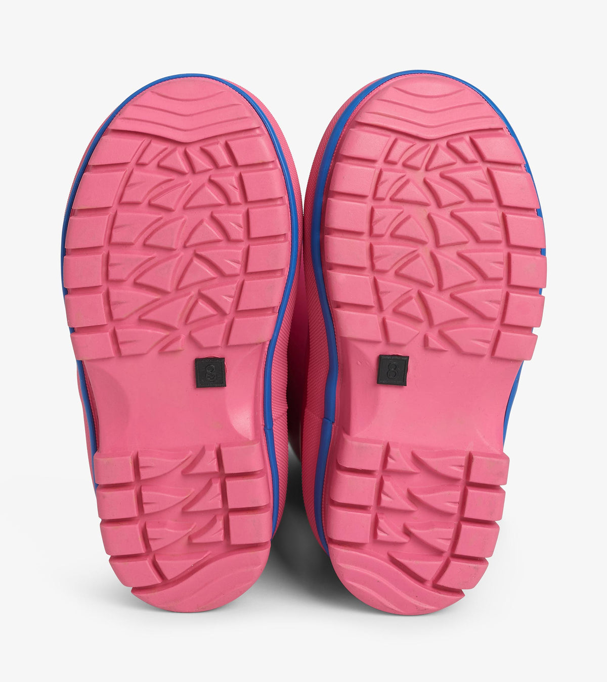 Bottom view of pink kids' boots showing textured tread soles