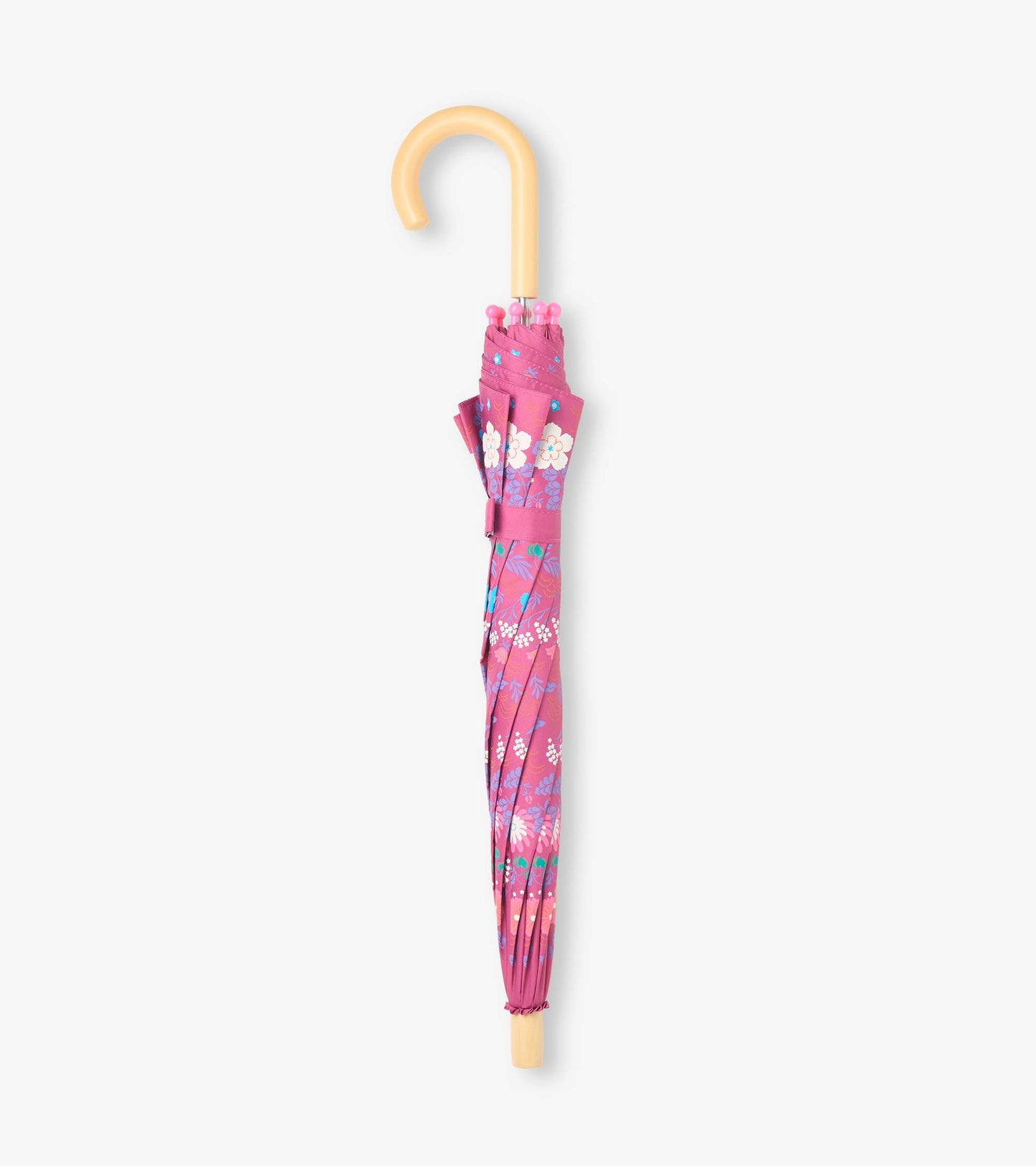 Closed pink umbrella with tiny flower print and curved light wood-tone handle