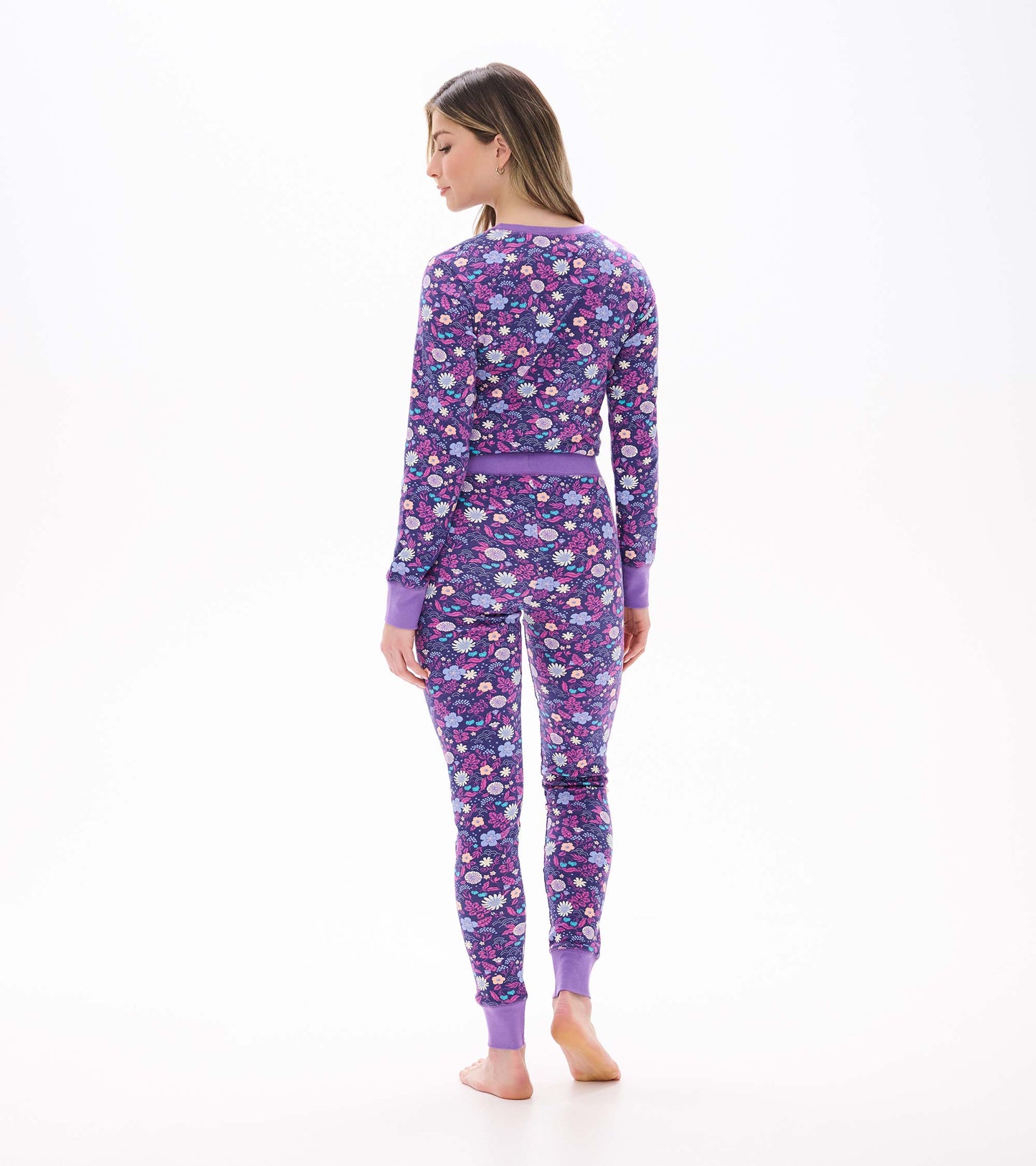 Back view of women's purple floral pajama set with long sleeves, matching pants, and purple cuffs