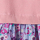 Pink ribbed fabric above a floral patterned fabric with purple, blue, and pink flowers