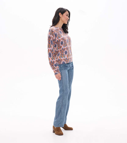 Side view of Noa sweater with crew neckline and pink, brown, blue and teal ikat pattern