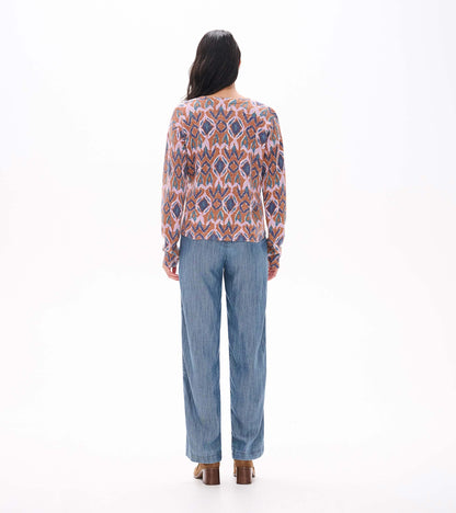 Back view of Noa sweater with pink, brown, blue and teal ikat pattern and straight hem