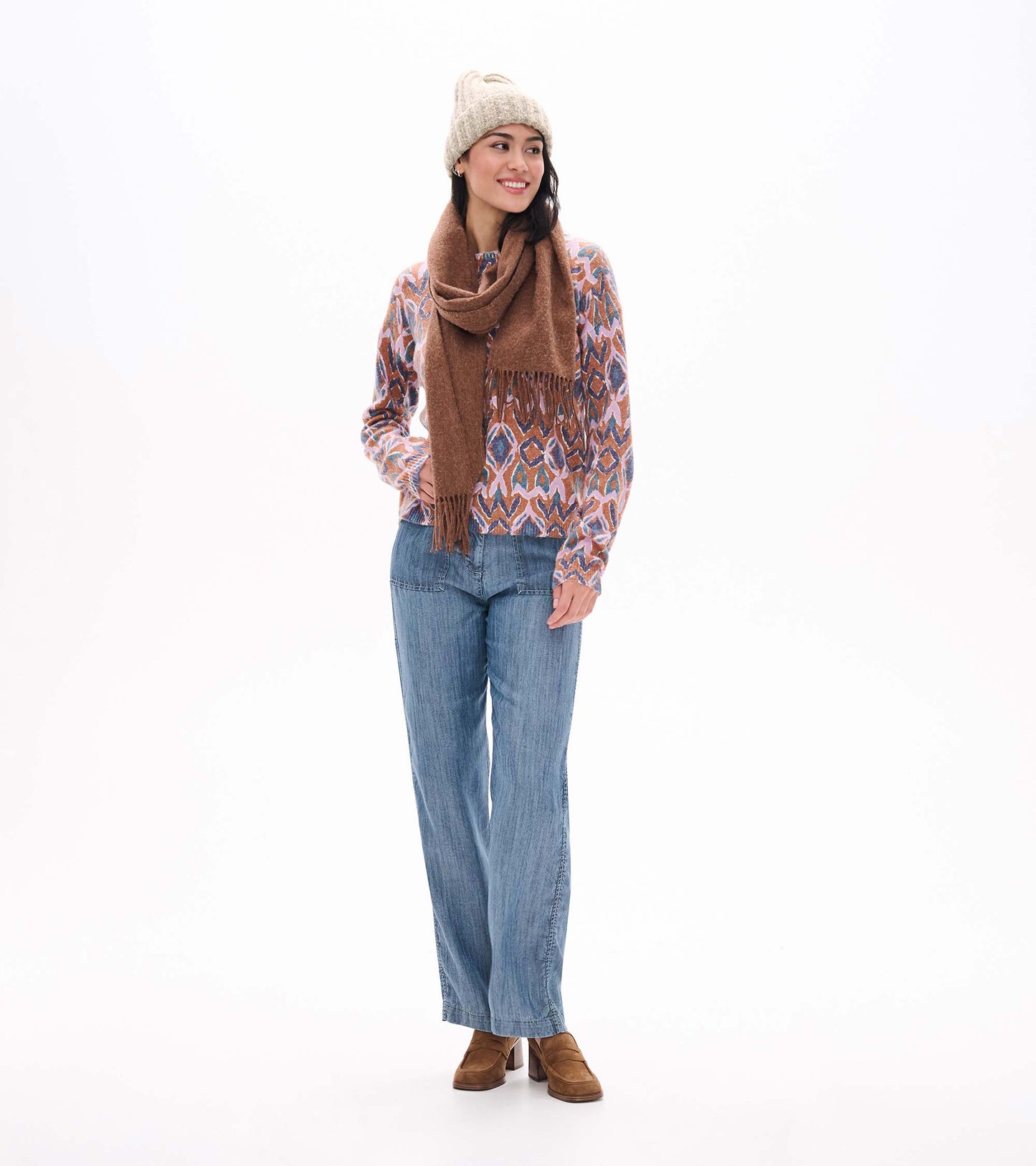 Noa sweater with pink, blue, and brown ikat pattern, shown styled with a brown scarf, knit hat, and jeans
