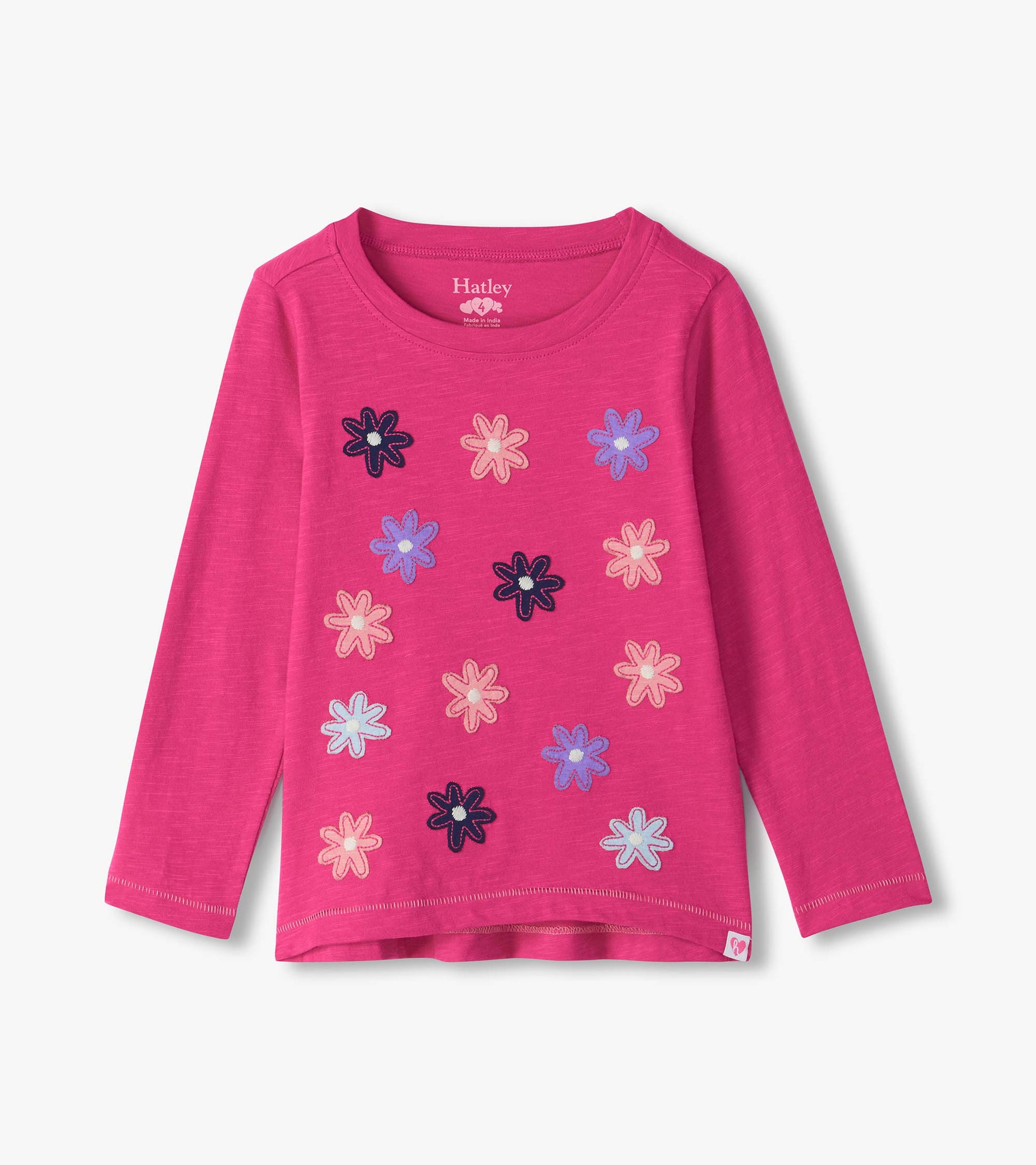 Bright pink long sleeve tee with scattered flower graphics in navy, pink, light blue, and purple