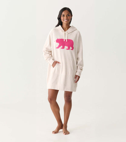 Cream oversized hoodie dress with pink bear graphic, hood, drawstrings, and front pocket, worn on model