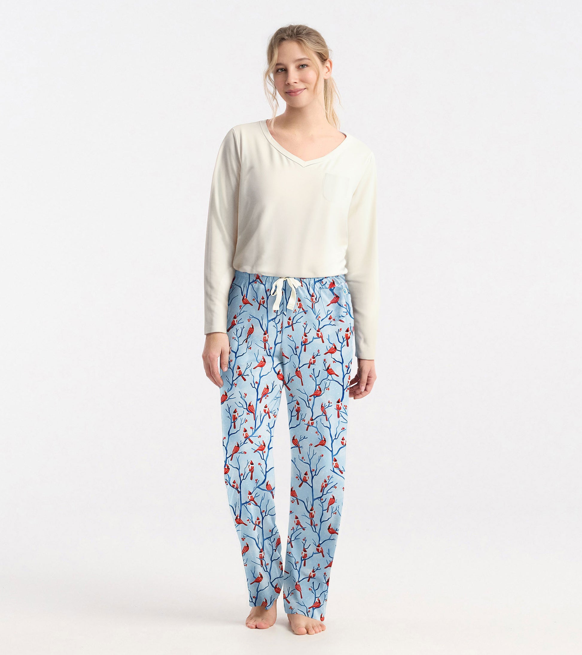 Cream long sleeve t-shirt with a v-neck and pocket, paired with patterned blue pajama pants featuring red birds.