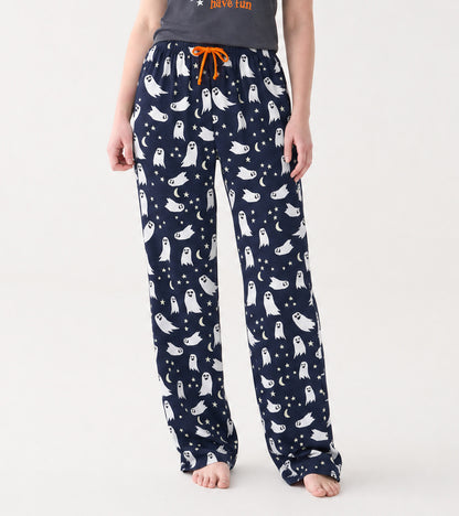 Model wearing navy pajama pants with white ghost, star and crescent moon print and orange drawstring
