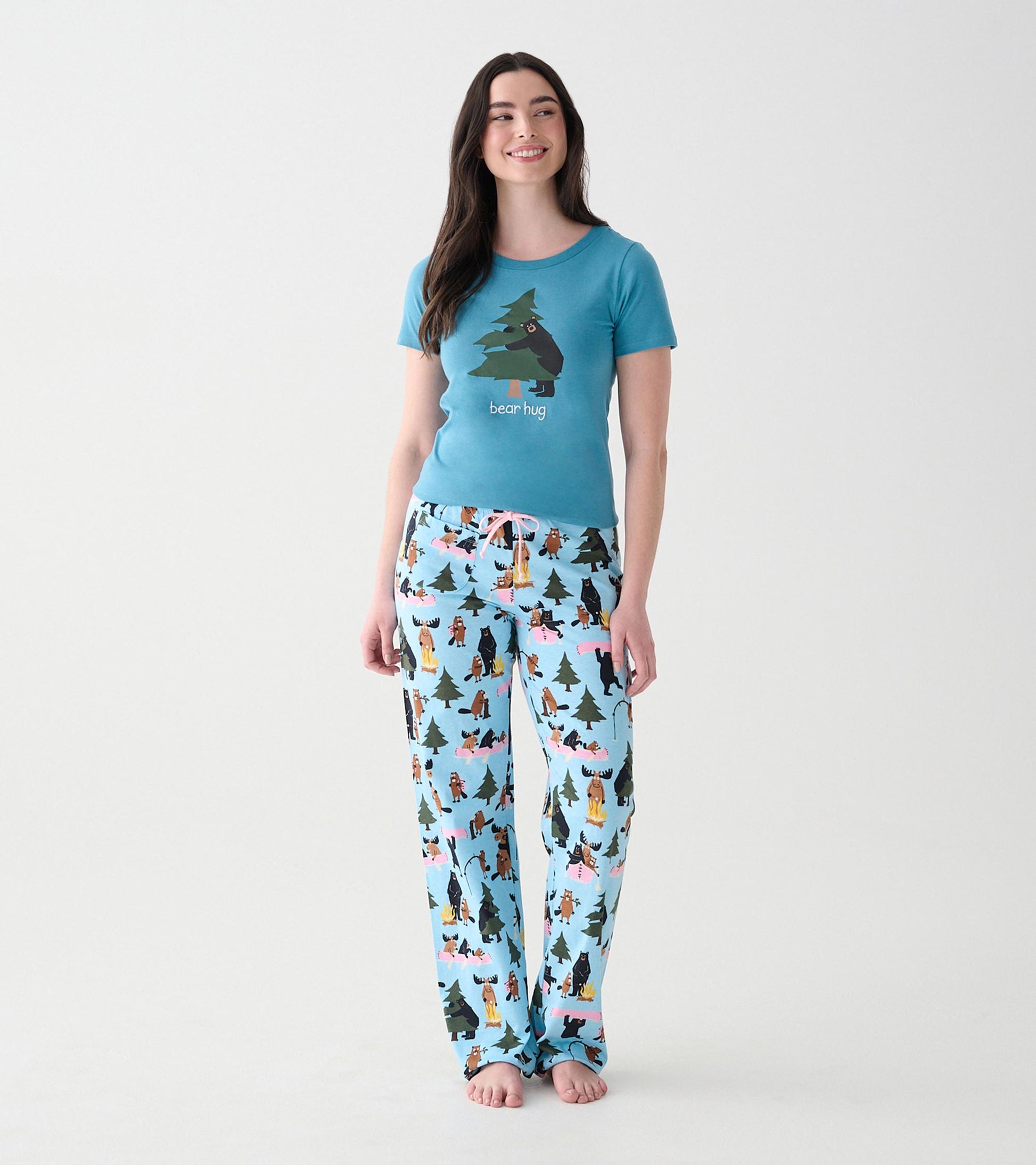 Women's light blue pajama pants shown on model, front view, with pink drawstring and woodland animal print