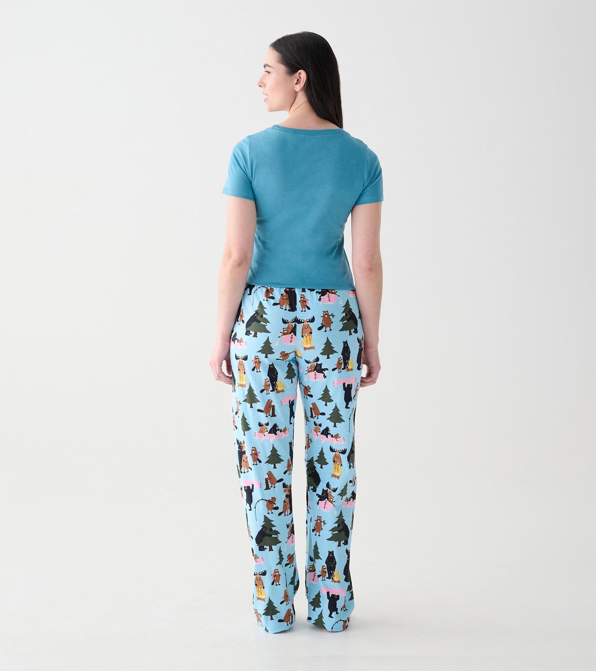 Back view of women's light blue pajama pants with woodland animal, tree and campfire print