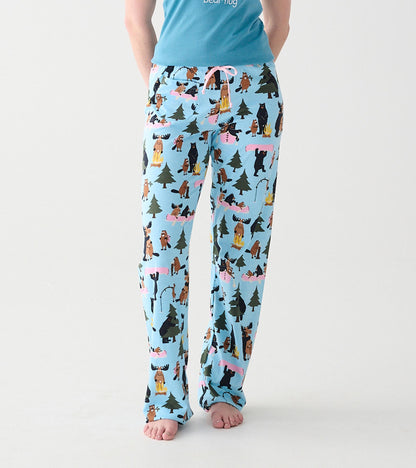 Front view of light blue pajama pants with pink drawstring and woodland animal, tree and campfire print