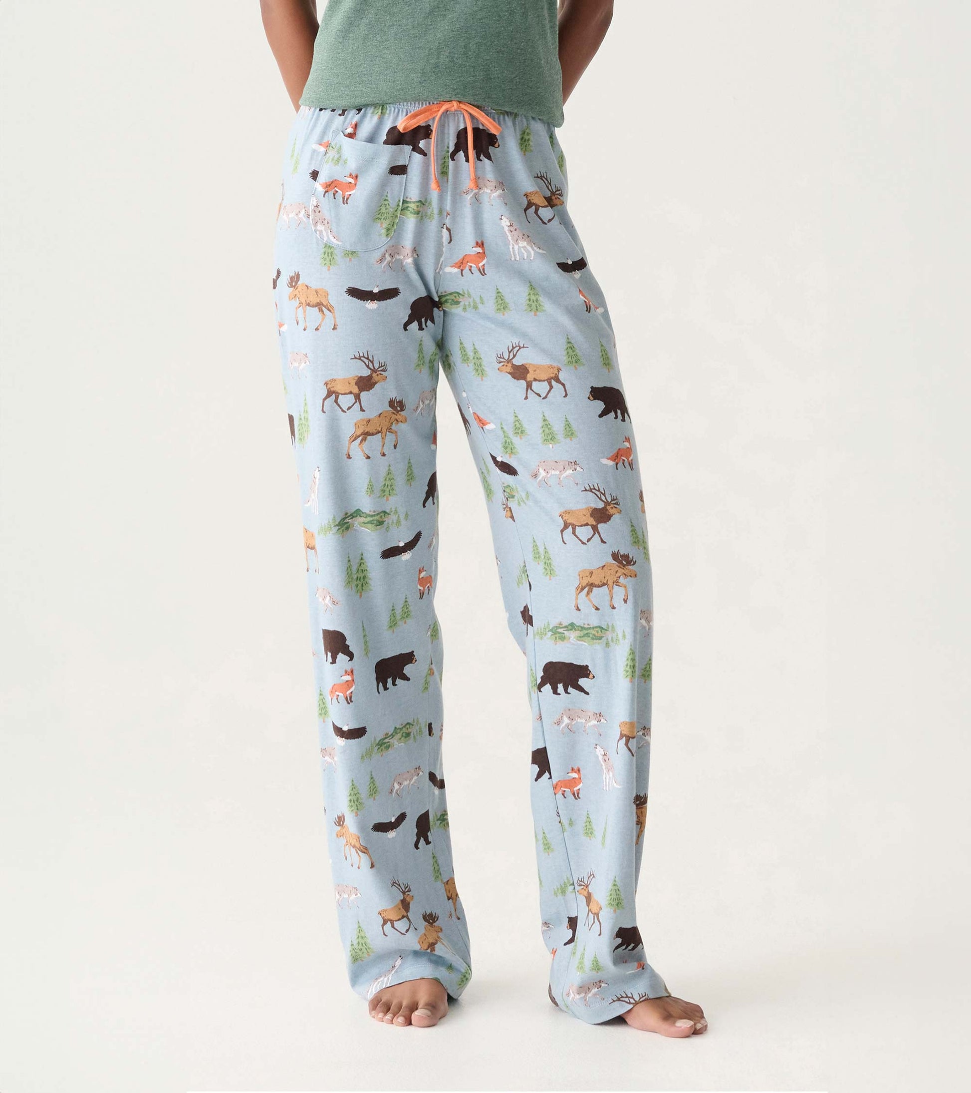 Light blue pajama pants with woodland animal and tree print, orange drawstring, and side pocket, front view