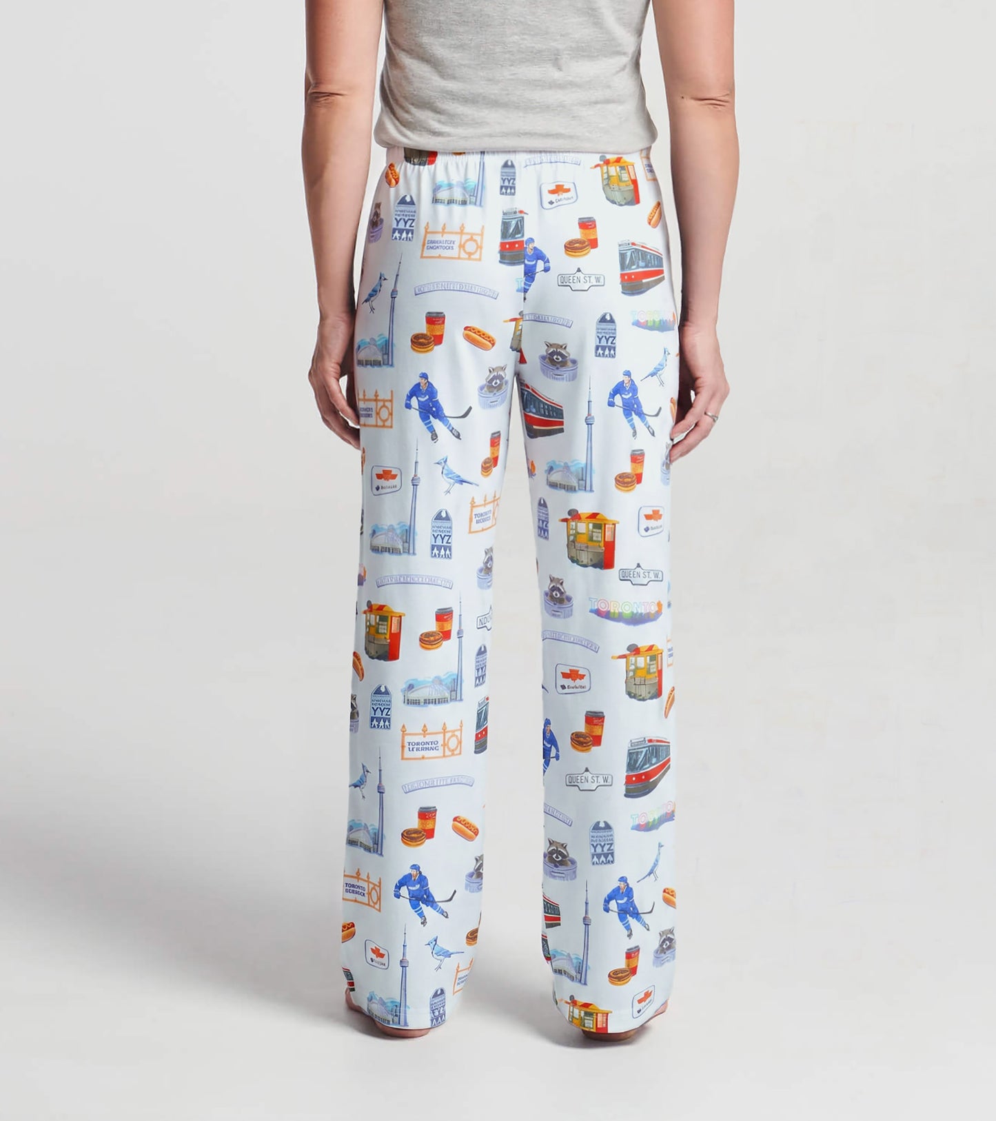 Back view of women's white pajama pants with colorful Toronto landmark and streetcar print