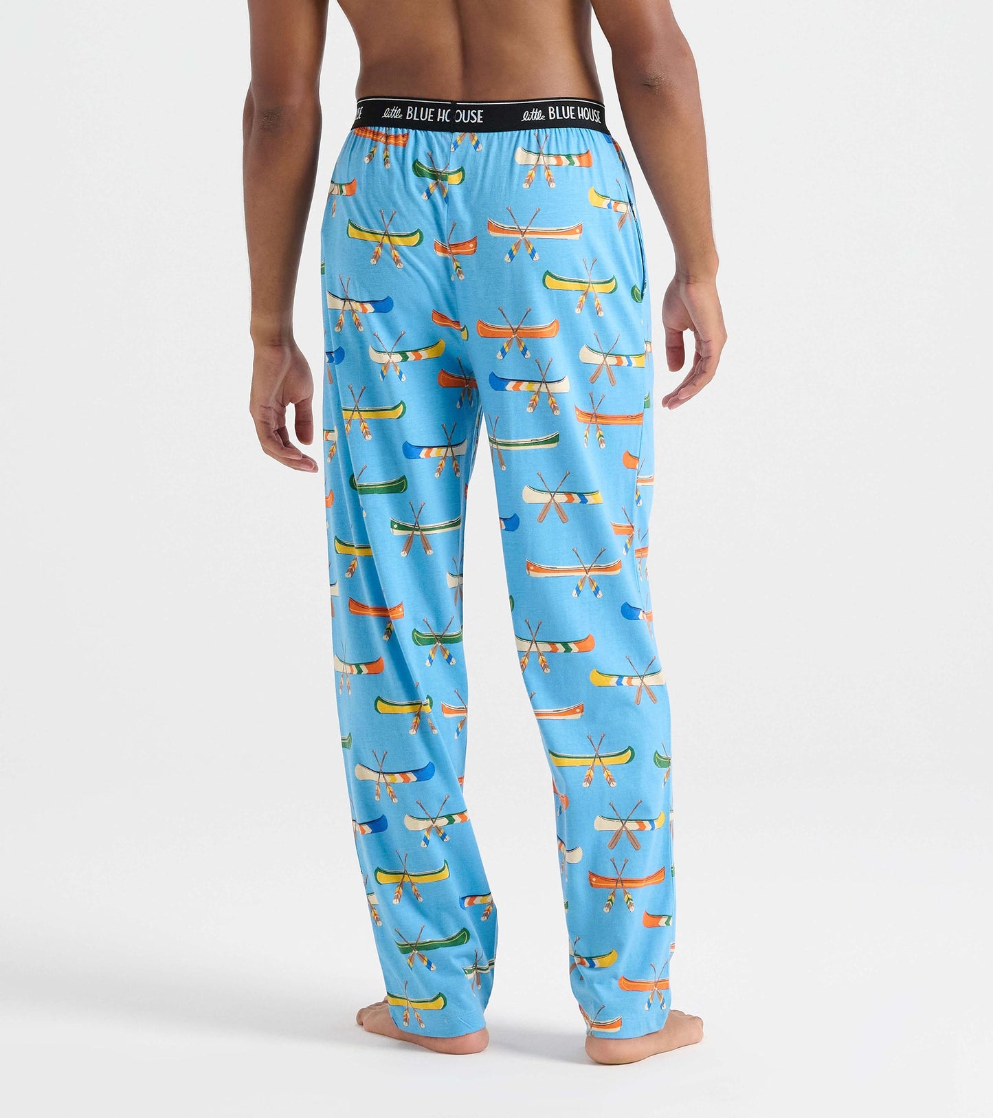 Back view of men's blue pajama pants with colorful canoe and crossed paddle print and black logo waistband