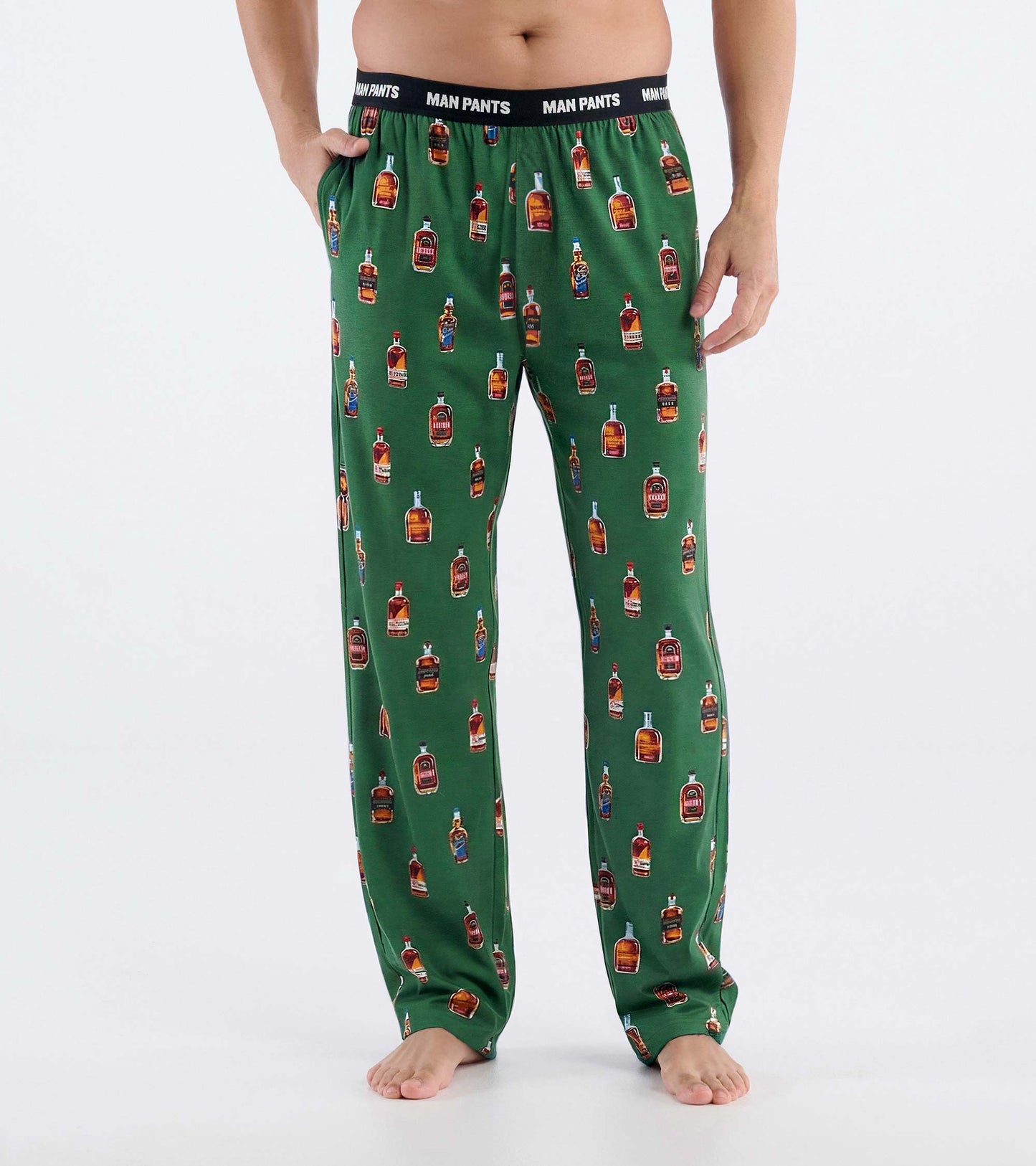 Green pajama pants with bourbon bottle print and black elastic waistband, front view on model