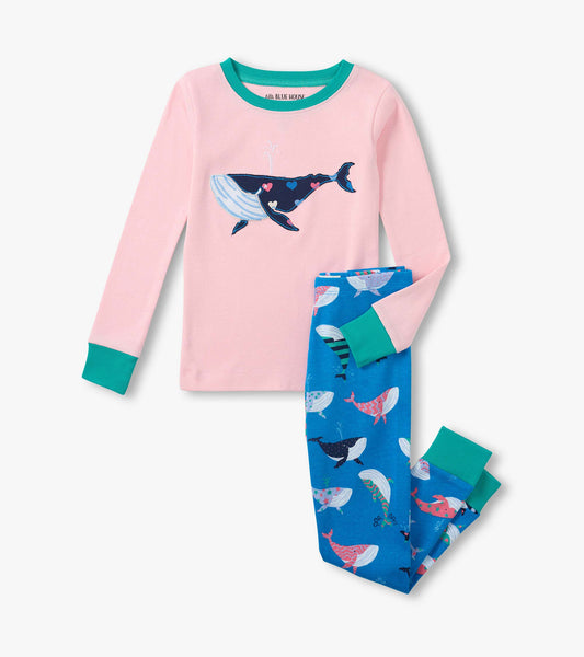 Pink long-sleeve kids pajama top with teal trim and whale graphic, paired with blue whale-print pajama pants.