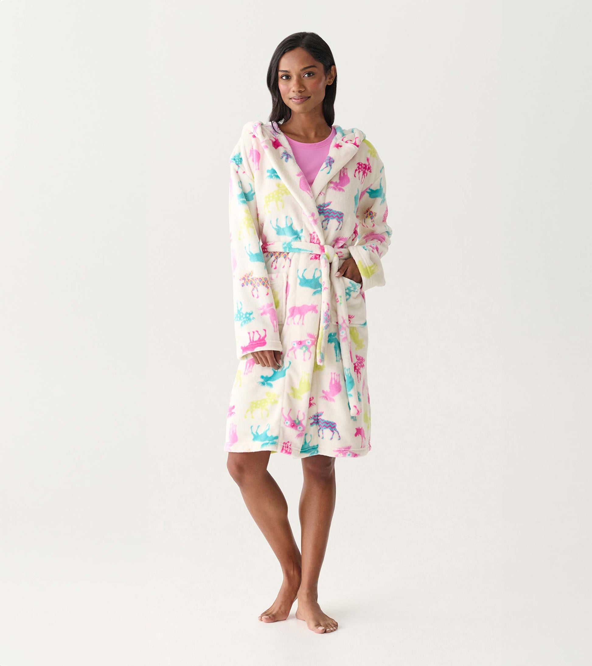 Woman wearing a white fleece robe with colorful moose print, tie waist, and hood, front view
