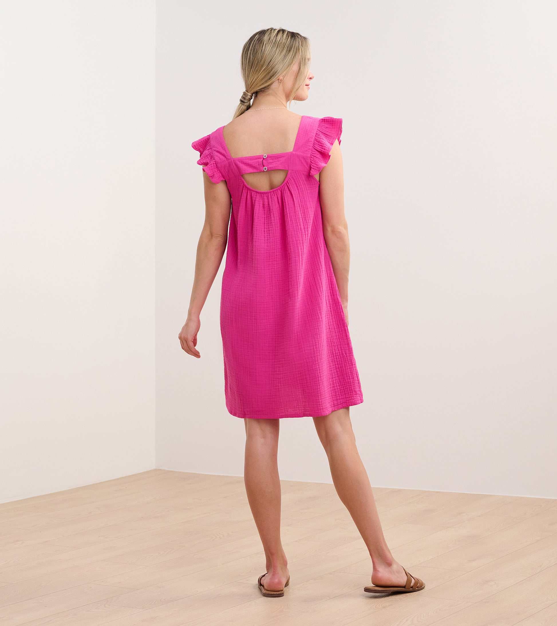 Back view of a fuchsia sleeveless dress with flutter sleeves, square back cutout, and knee-length hem
