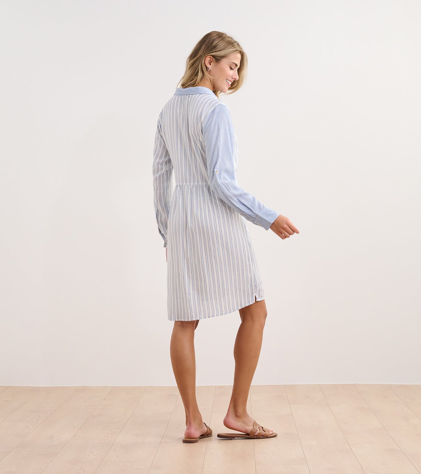 Light blue shirt dress with vertical stripes, long sleeves, and a relaxed fit, shown from the back.
