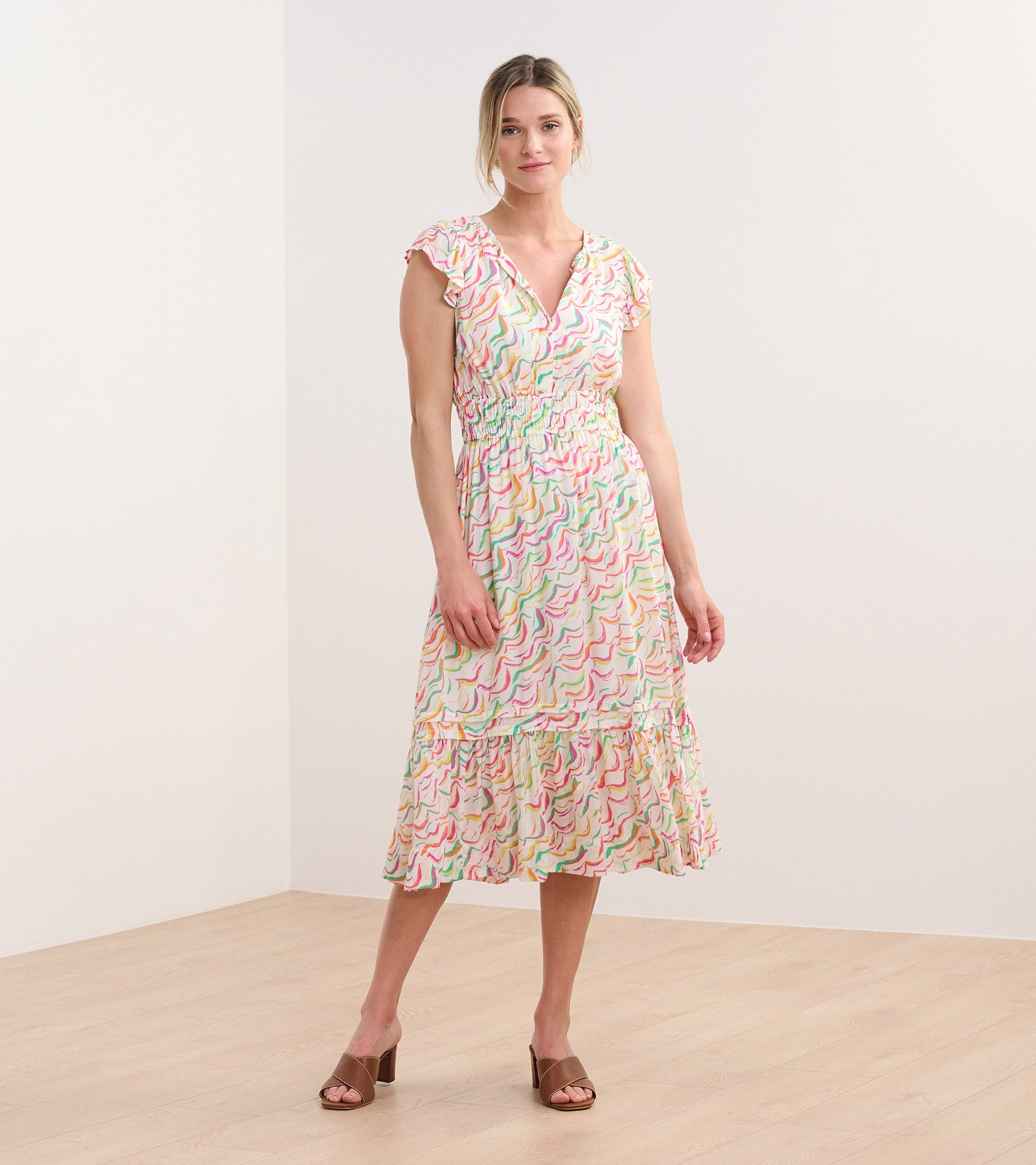 Midi dress featuring wavy stripes in pastel colors, with a smocked waist and ruffled sleeves.
