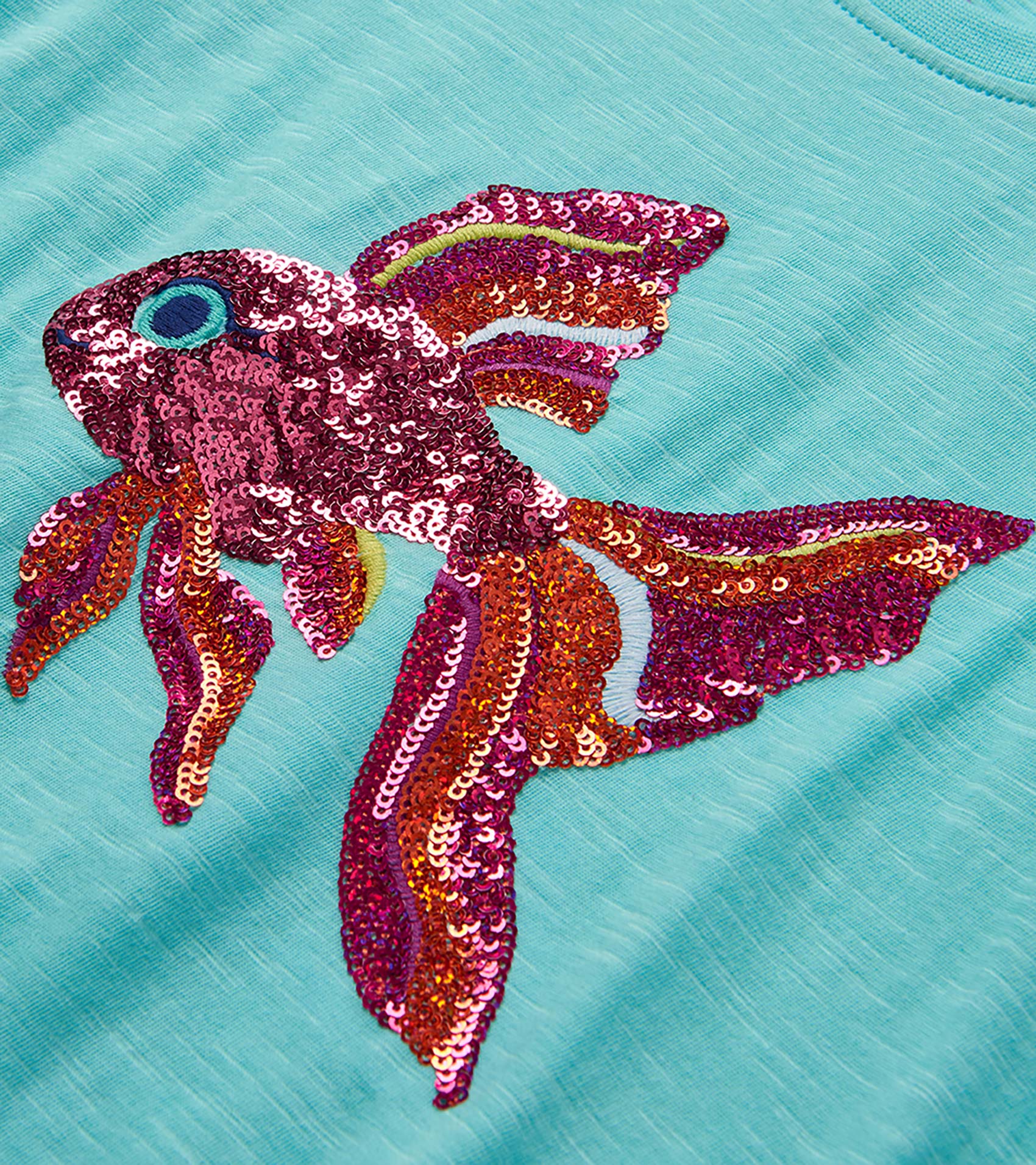 Turquoise girls T-shirt with large multicolor sequined tropical fish graphic on the front