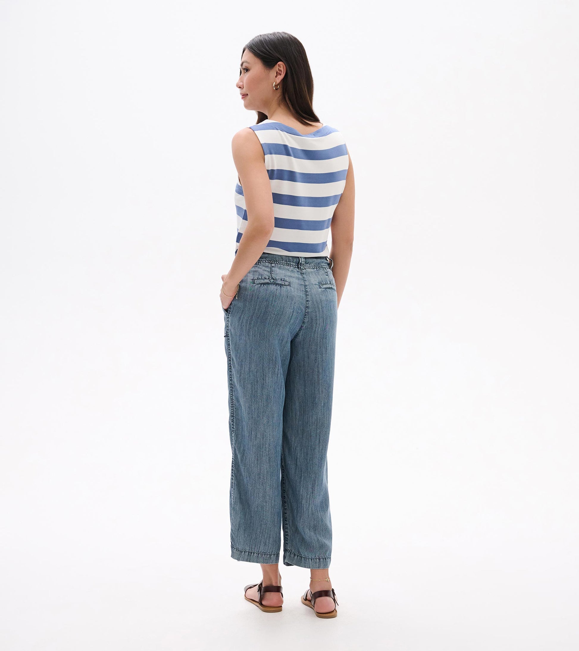 Back view of blue acid-wash wide-leg denim pants with cropped hem and pockets