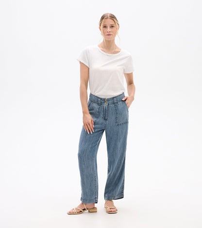 Front view of blue acid-wash wide-leg pants with high waist, button fly, and patch pockets on a model