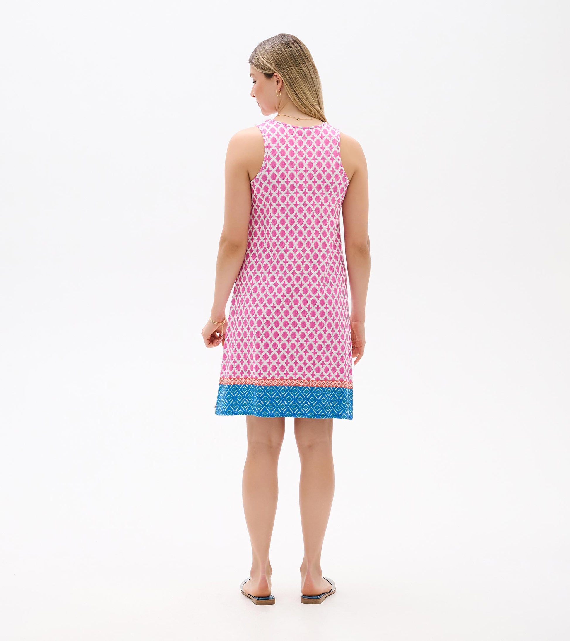 Back view of a sleeveless pink patterned dress with blue geometric hem and knee-length cut